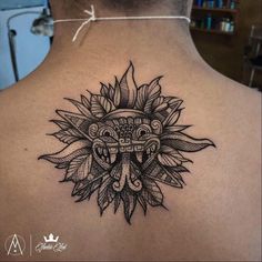 the back of a woman's neck with an intricate tattoo design on it,