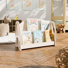 a wooden toy book rack with books on it and stuffed animals in the background,