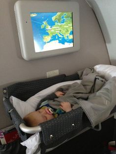 a baby is laying in a crib with a map on the wall behind it