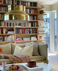 a living room filled with lots of books and furniture