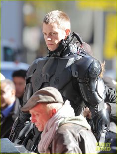 a man in a futuristic suit walking with another man