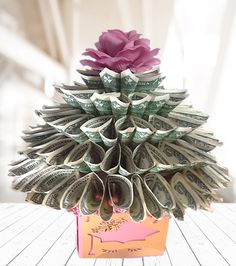 a flower made out of money sitting on top of a table