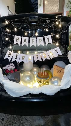 an open trunk filled with lots of birthday decorations and lights on the top of it