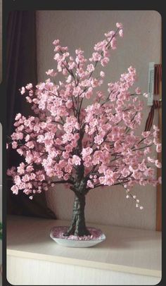 a tree with pink flowers on top of a table