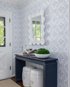 a bathroom with blue and white wallpaper on the walls, a bowl of green moss