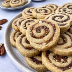 a white plate topped with cookies and pecans on top of a blue table cloth