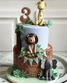 a three tiered cake decorated with animals and numbers on it's top layer