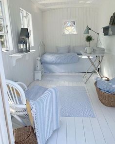 a room with white walls and flooring has blue blankets on the bedspreads