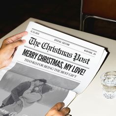 a person is holding up a christmas newspaper