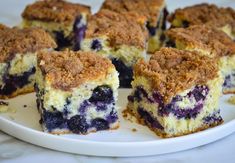 blueberry coffee cake on a white plate with the words, blueberry coffee cake boy bah