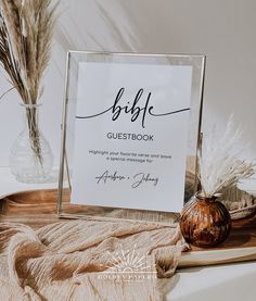 a menu sitting on top of a wooden table next to a vase filled with dry grass