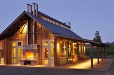 a large wooden building with lots of windows and lights on it's sides, lit up at night