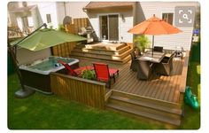 a hot tub sitting on top of a wooden deck next to a table and chairs