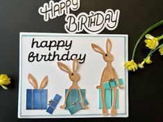 a happy birthday card with two rabbits holding presents and flowers in front of the words happy birthday