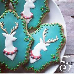 decorated cookies with green icing and white frosting on a plate