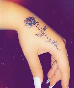 a woman's hand with a rose tattoo on it and the word love written in cursive writing