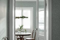 a table and chairs in a room with green wallpaper