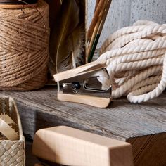 a pair of scissors sitting on top of a wooden table next to twine and rope