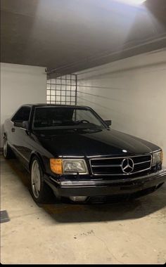 a black mercedes benz parked in a garage