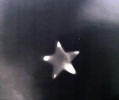 a black and white photo of a star in the sky