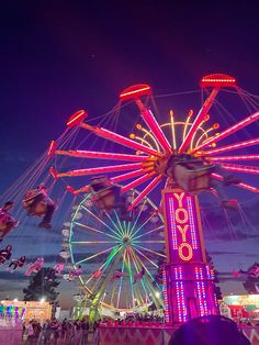 the ferris wheel is lit up at night