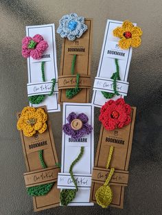 six crocheted flower headbands in different colors and sizes are on display