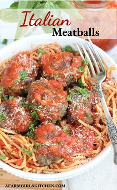 meatballs with tomato sauce and parmesan cheese in a white bowl next to a fork