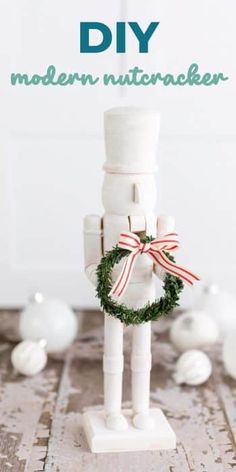 a christmas nutcracker made out of toilet paper with a wreath around it and the words diy modern christmas nutcracker