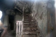 an old run down building with stairs and graffiti on the walls