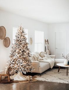 a living room with a white christmas tree in the corner and decorations on the wall