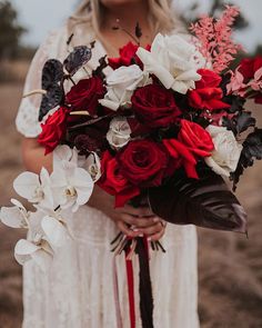 a woman holding a bouquet of red and white flowers