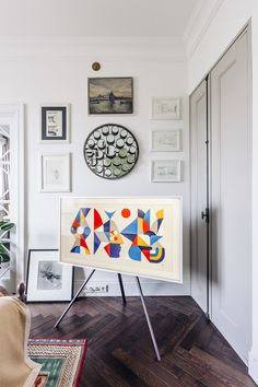 a living room with white walls and pictures on the wall