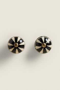 pair of black and white striped earrings with gold accents on the front, back and sides