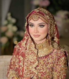 a woman in a red and gold wedding outfit