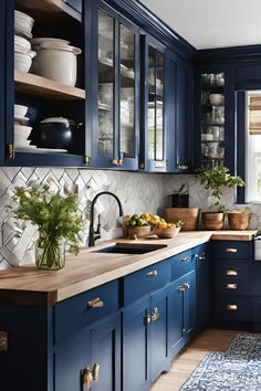 a kitchen with dark blue cabinets and wooden counter tops, an area rug on the floor