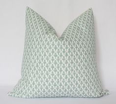 a green and white pillow sitting on top of a white wall