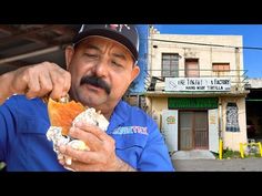 a man in blue shirt and hat eating food