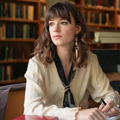 a woman sitting at a table with a pen in her hand