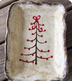 a white dish with a red christmas tree painted on it