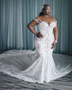 a woman in a wedding dress standing on a bed with her hands on her hips