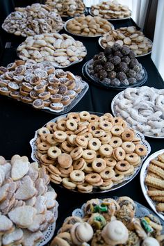 a table topped with lots of different types of cookies and pastries next to each other