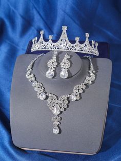 a tiara and necklace set on display in a blue box with a blue satin background