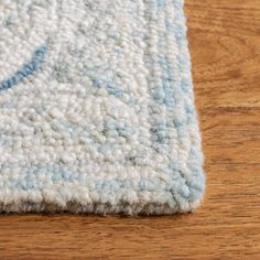 a blue and white area rug on a wooden floor with a wood floor in the background