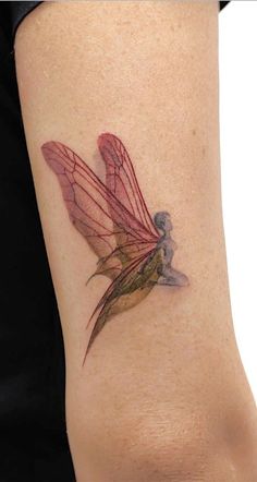 a woman's leg with a tattoo on it that has a red and green dragonfly