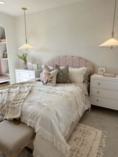 a bedroom with a large bed and white furniture