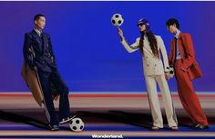 three people dressed in suits and holding soccer balls