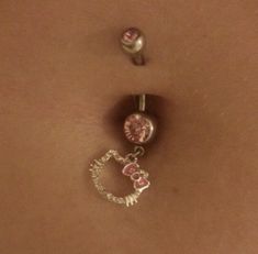 a woman's belly with two charms attached to it