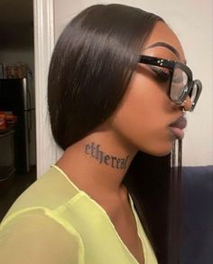 a woman wearing glasses with the word ether tattooed on her neck