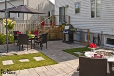 an outdoor patio with table, chairs and grill