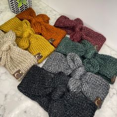 Welcome to the cozy world of Bow'Ho & Co, where style meets comfort! Introducing our Super Soft Warm Knit Bow Headbands, the perfect blend of bohemian charm and practical warmth. Each headband is crafted with love using the softest acrylic yarn, ensuring a gentle, itch-free experience for all-day wear. Available in a spectrum of 7 gorgeous hues - taupe, evergreen, black, gray, rust, plum, and mustard - these headbands add a pop of color to any outfit. Measuring 3 inches wide, they comfortably fit 20 to 23 inches in circumference for adults and 16 to 19 inches for kids. Plus, for those needing a custom size, we're happy to accommodate at no extra charge. Just message us your requirements! Not just a pretty accessory, these headbands are adorned with a chic faux leather tag, adding a touch o Knit Bow, Bow Headbands, Outdoor Cafe, Boho Look, Jewelry Earrings Hoops, Bow Headband, Tumble Dryer, Acrylic Yarn, Black Gray